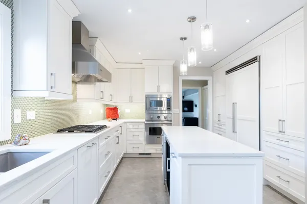 a kitchen that has a lot of cabinets in it and wooden floors