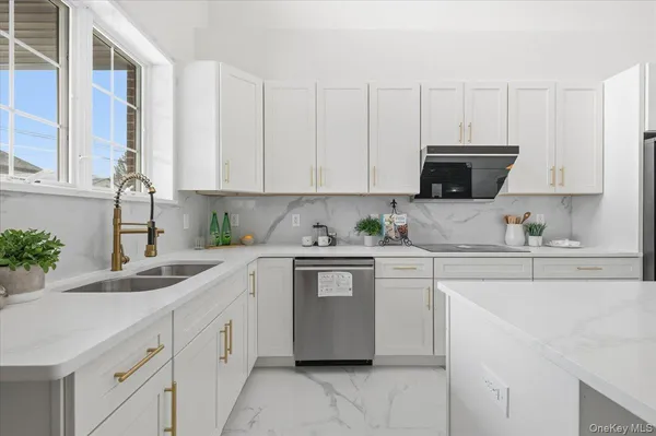 a kitchen with granite countertop white cabinets white appliances and a sink