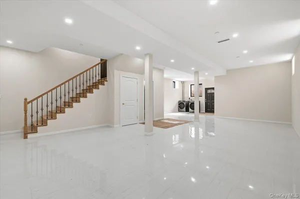 a view of a hallway with a dining table chairs stairs and a chandelier