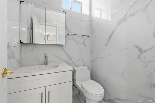 a bathroom with a sink a toilet and a mirror