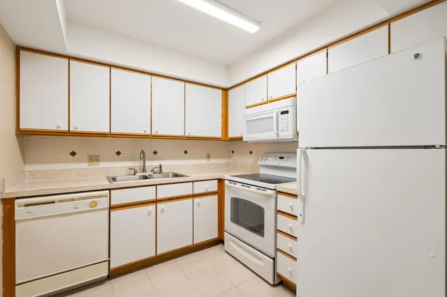 a kitchen with cabinets appliances a sink and a window