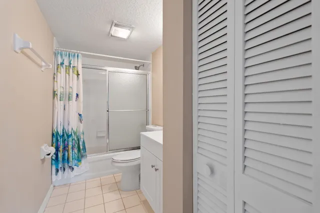 a bathroom with a granite countertop shower and a toilet