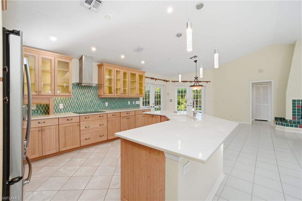 716 Pitch Apple Lane Naples, FL 34108 - Photo 18 of 36 a large kitchen with granite countertop a sink and dishwasher a stove with wooden floors