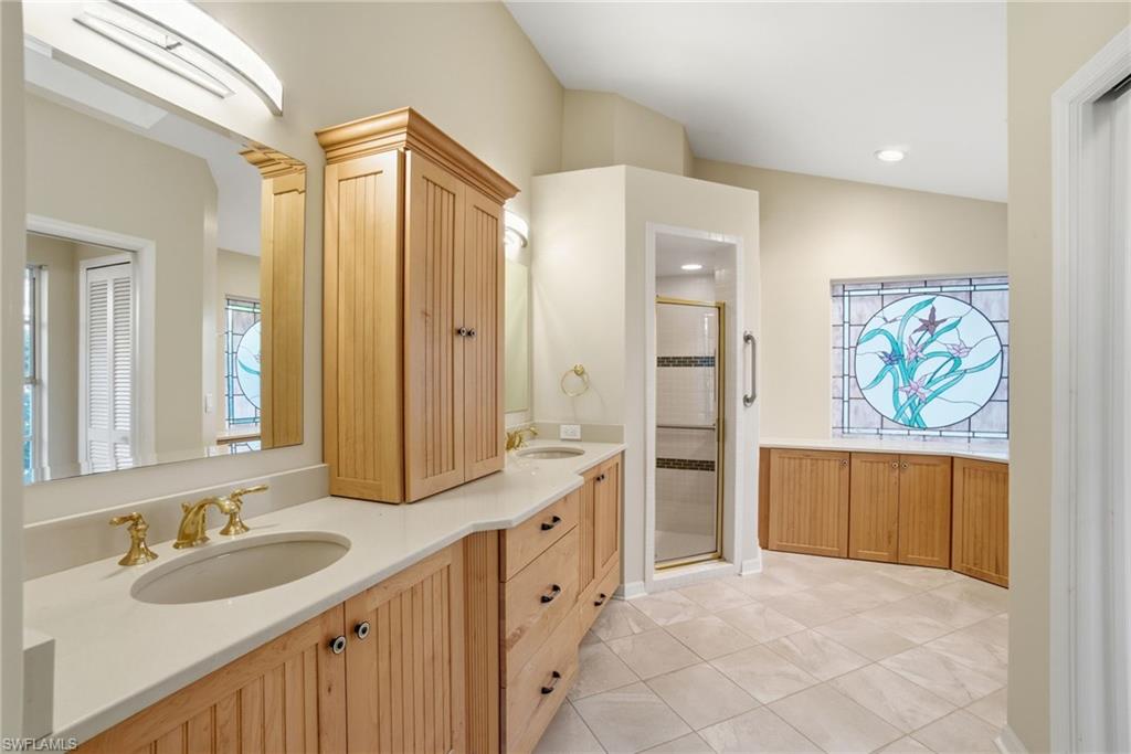 716 Pitch Apple Lane Naples, FL 34108 - Photo 22 of 36 a spacious bathroom with a granite countertop double vanity sink mirror and a bathtub
