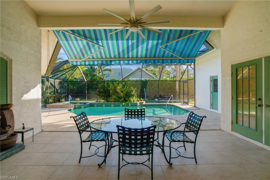 716 Pitch Apple Lane Naples, FL 34108 - Photo 9 of 36 a view of patio with table and chairs under an umbrella