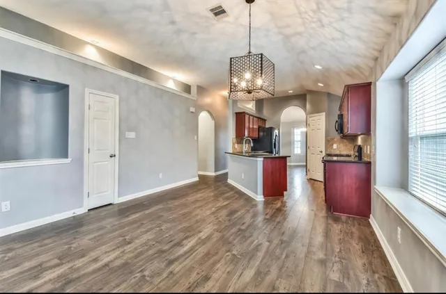 a view of a kitchen and an empty room