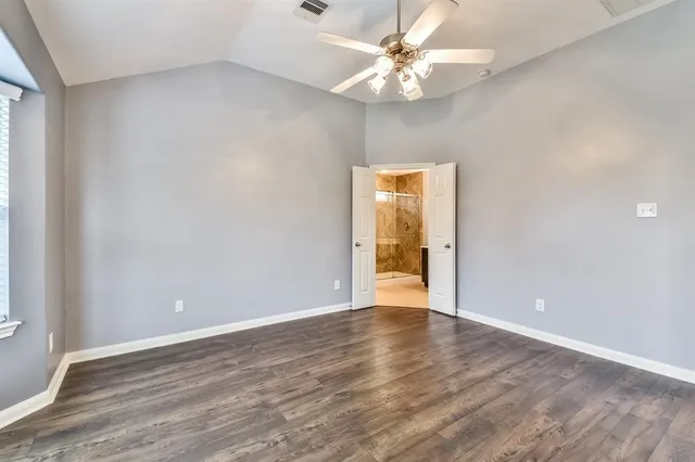 a view of an empty room with glass door and a window