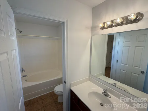 a bathroom with a sink a toilet a mirror and shower