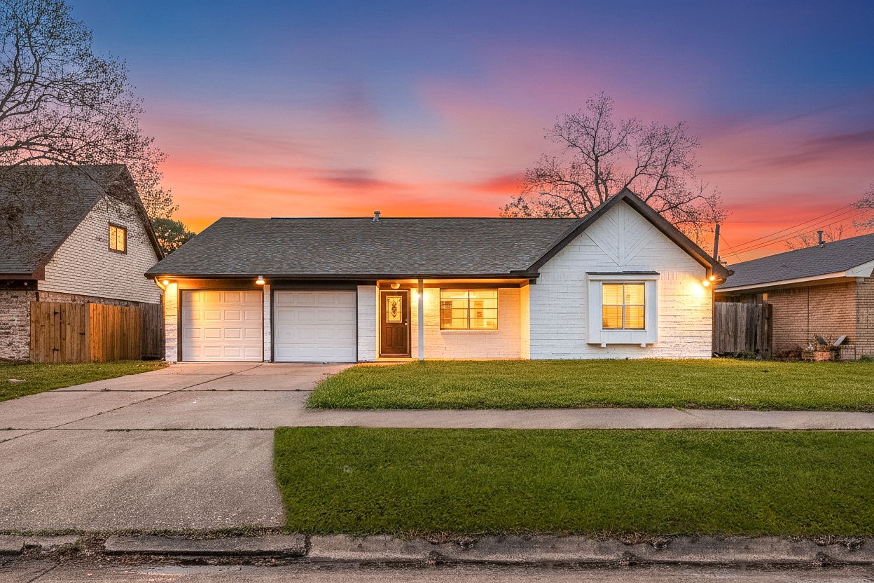 a front view of house with yard and trees in the background