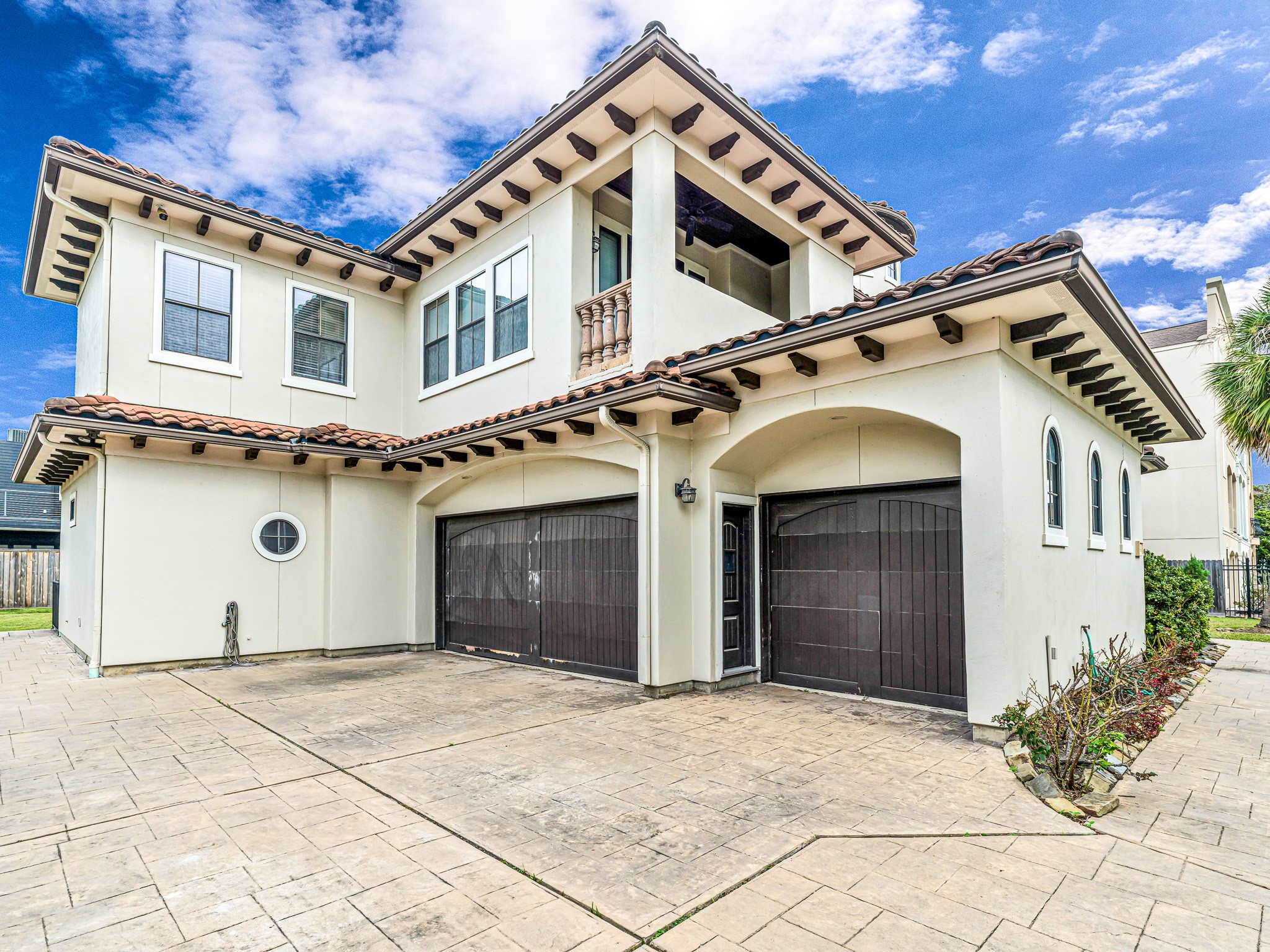 4614 Inker Street Houston, TX 77007 - Photo 2 of 36 Stucco exterior with a tiled roof. The home includes a spacious driveway leading to a 3-car garage with dark wooden doors and built-ins throughout the interior.