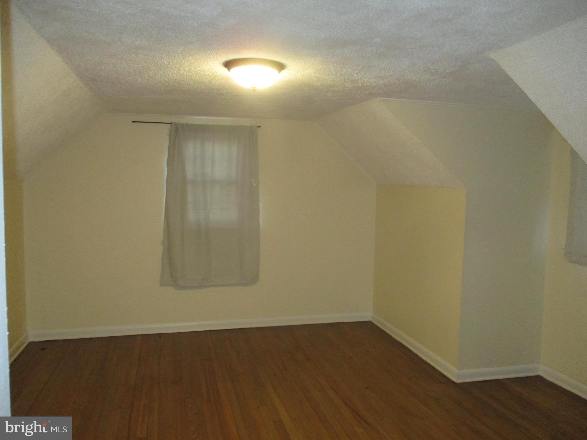 121 Hoover Avenue Hamilton, NJ 08619 - Photo 11 of 12 an empty room with wooden floor and windows