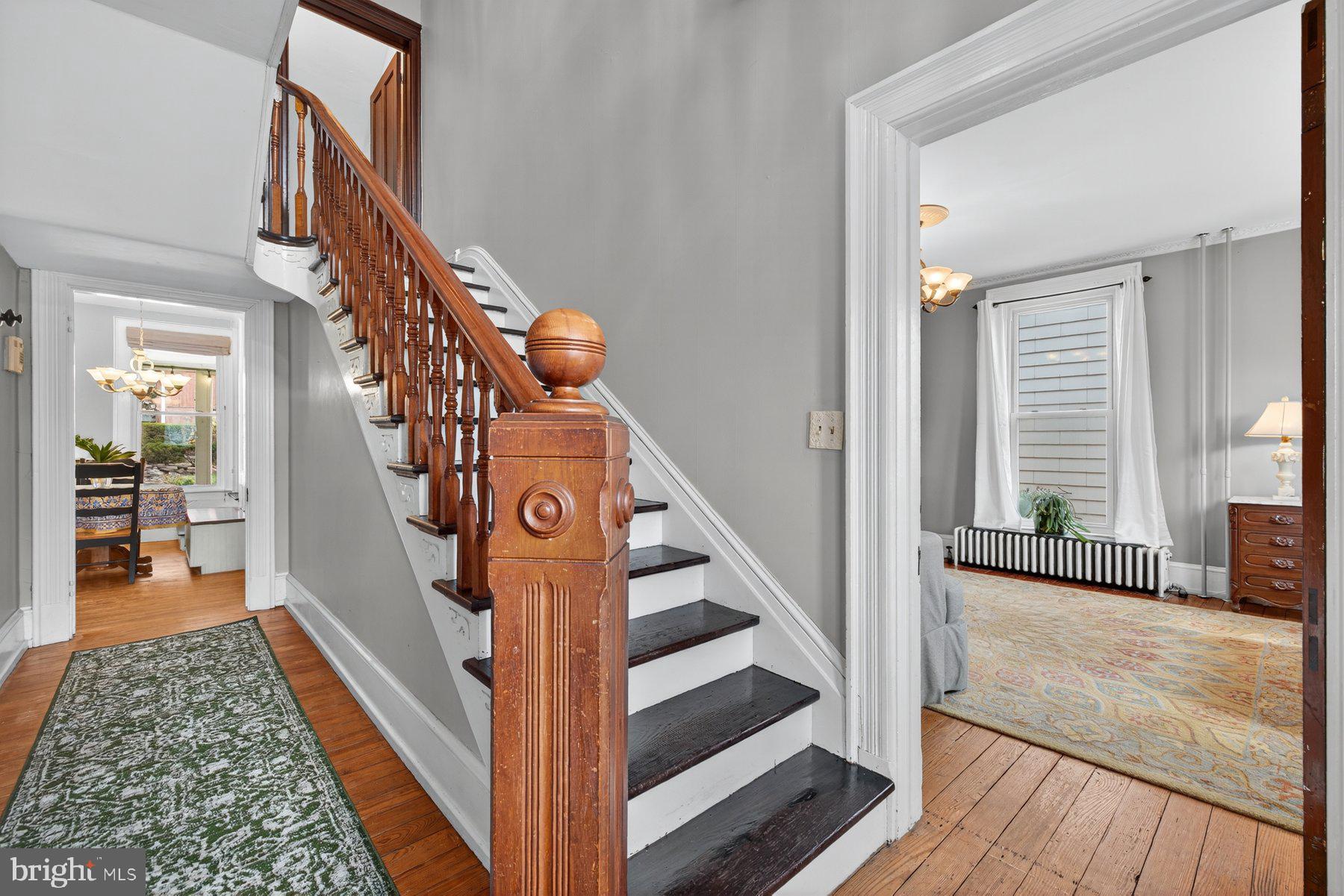 58 East Baltimore Street Taneytown, MD 21787 - Photo 21 of 56 a view of a hallway to a livingroom with wooden floor and stairs