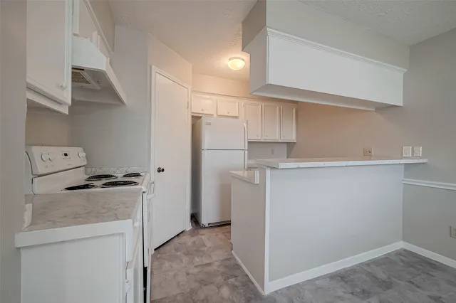 a kitchen with a refrigerator and a stove top oven