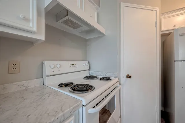 a white stove top oven sitting inside of a kitchen