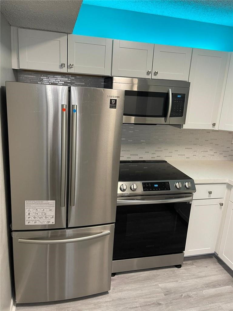 a kitchen with stainless steel appliances and wooden cabinets