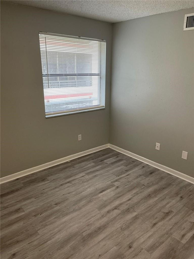1112 North Hiatus Road, Unit 1112 Pembroke Pines, FL 33026 - Photo 17 of 48 an empty room with wooden floor and windows