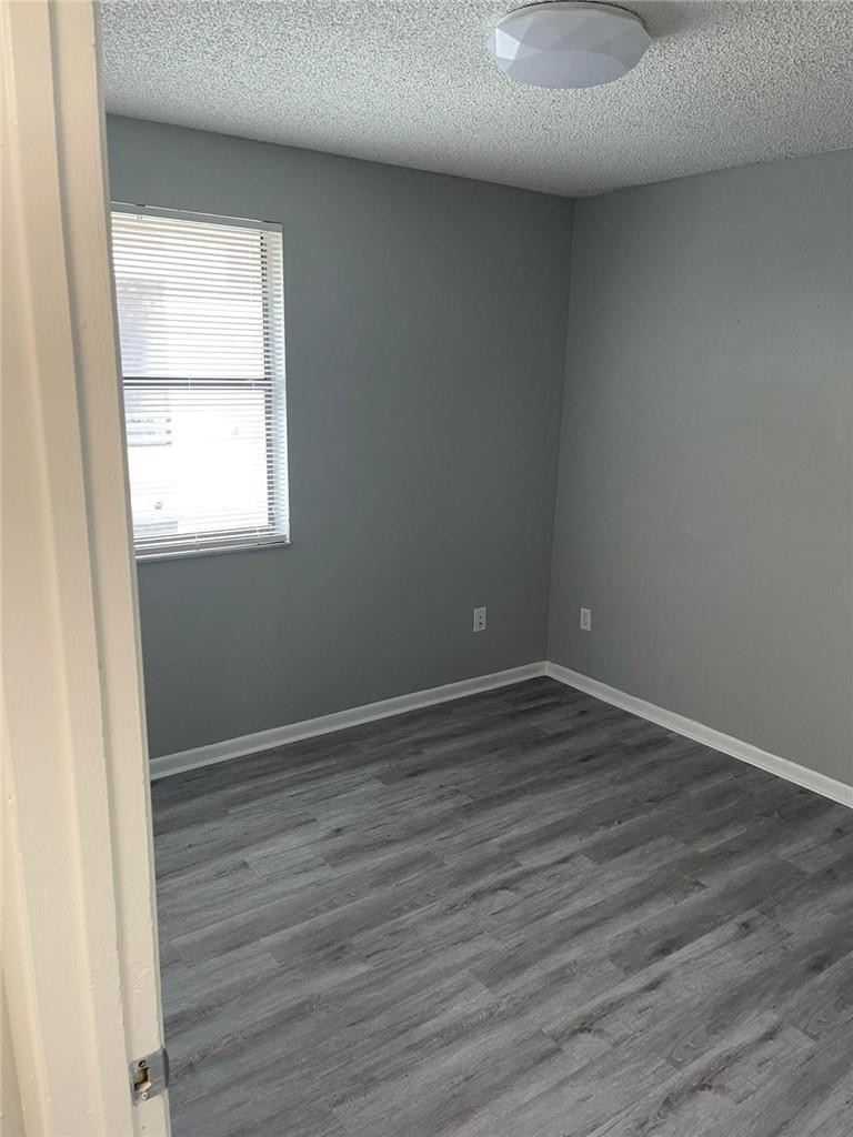 1112 North Hiatus Road, Unit 1112 Pembroke Pines, FL 33026 - Photo 19 of 48 an empty room with wooden floor and windows