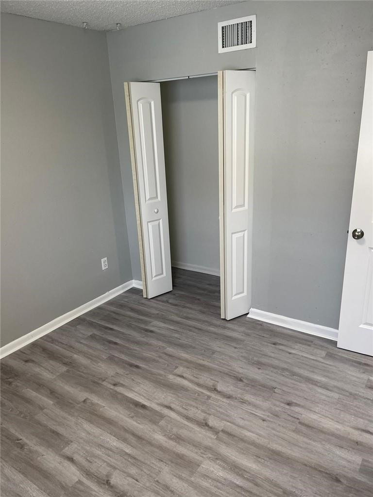 1112 North Hiatus Road, Unit 1112 Pembroke Pines, FL 33026 - Photo 20 of 48 an empty room with wooden floor and windows