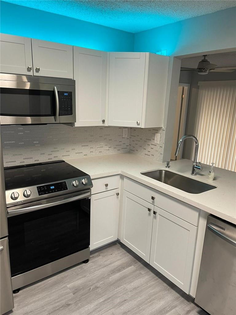 1112 North Hiatus Road, Unit 1112 Pembroke Pines, FL 33026 - Photo 2 of 48 a kitchen with stainless steel appliances a stove a sink and a microwave