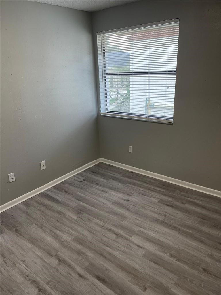 1112 North Hiatus Road, Unit 1112 Pembroke Pines, FL 33026 - Photo 21 of 48 an empty room with wooden floor and windows