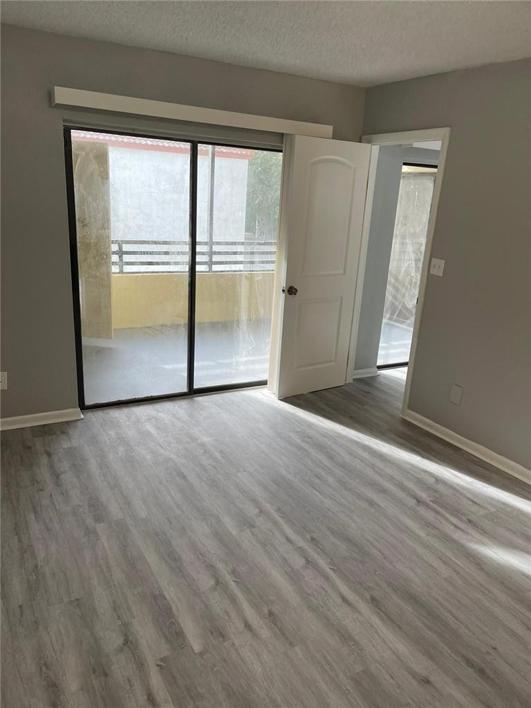1112 North Hiatus Road, Unit 1112 Pembroke Pines, FL 33026 - Photo 23 of 48 an empty room with wooden floor and door