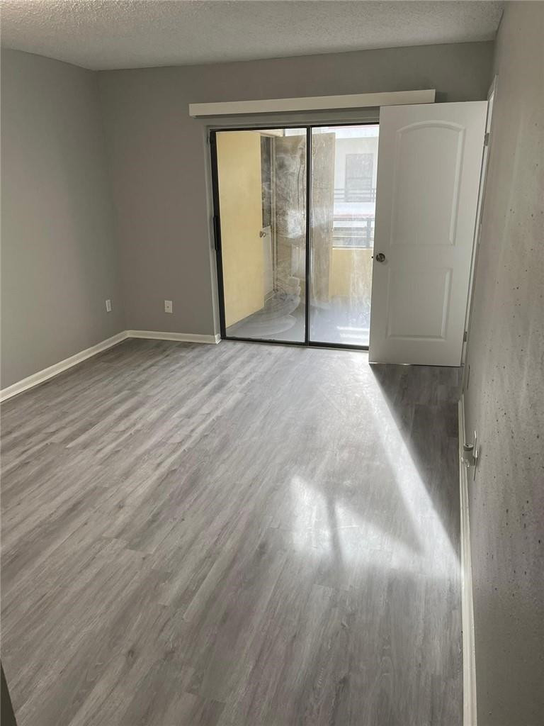 1112 North Hiatus Road, Unit 1112 Pembroke Pines, FL 33026 - Photo 29 of 48 an empty room with wooden floor and windows