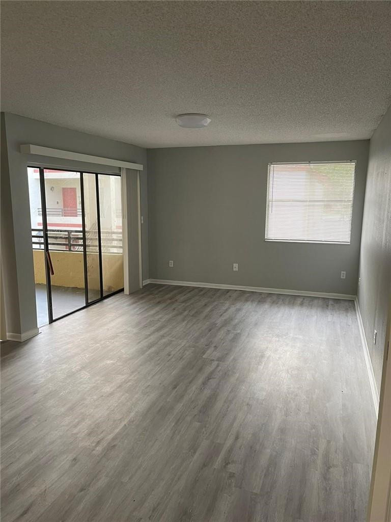 1112 North Hiatus Road, Unit 1112 Pembroke Pines, FL 33026 - Photo 6 of 48 an empty room with wooden floor and windows