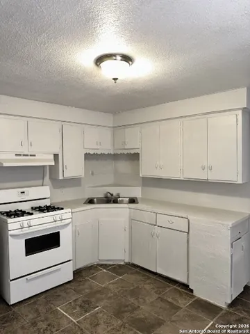 a kitchen with cabinets stainless steel appliances and sink