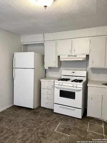 a stove top oven sitting inside of a kitchen