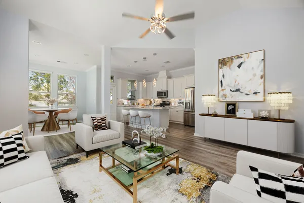 a living room with furniture kitchen view and a chandelier