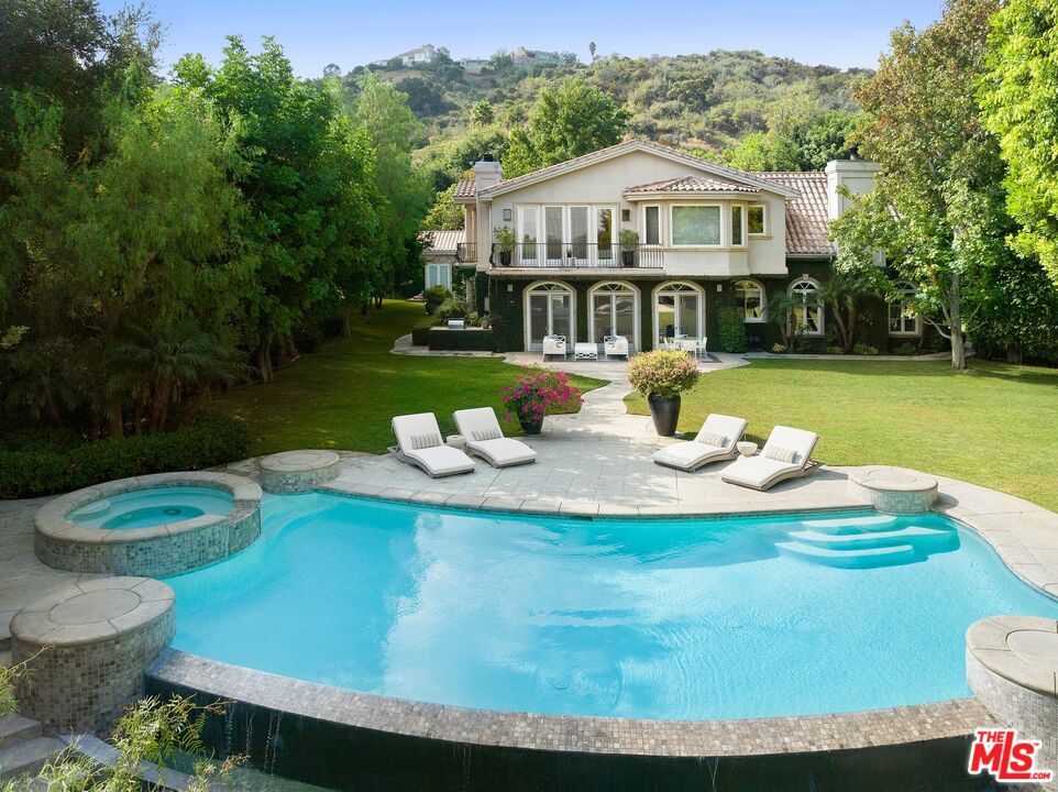 a view of a house with pool and chairs