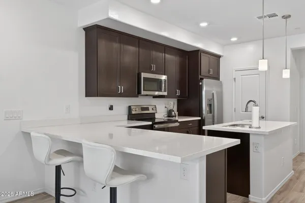 a living room with furniture kitchen and a flat screen tv