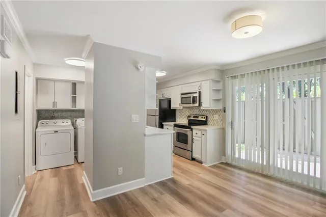 a kitchen with a refrigerator a stove top oven a sink and dishwasher with wooden floor