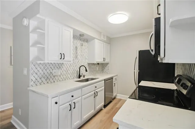 a kitchen with a sink dishwasher and white cabinets