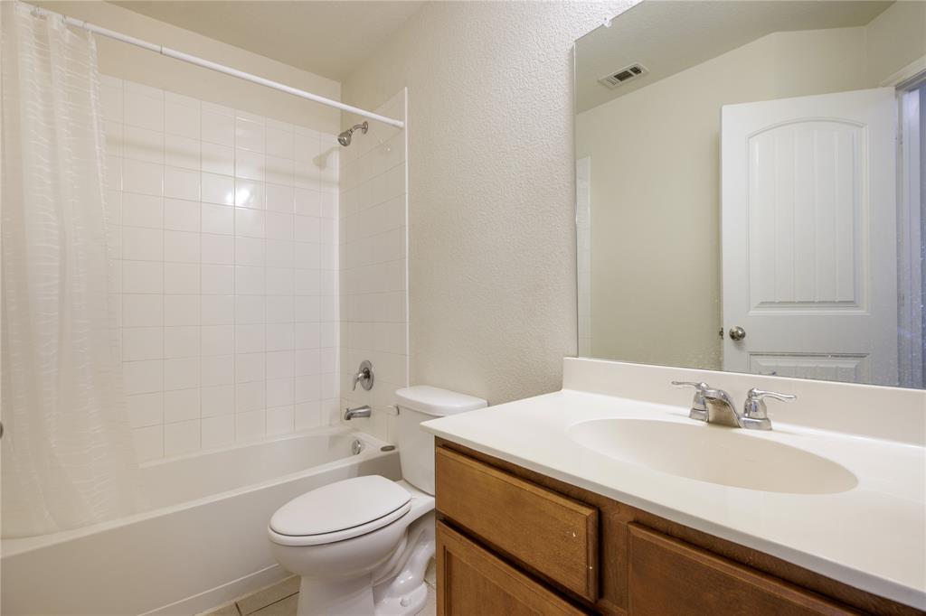 910 Amber Street Princeton, TX 75407 - Photo 14 of 24 a bathroom with a sink a toilet and a mirror