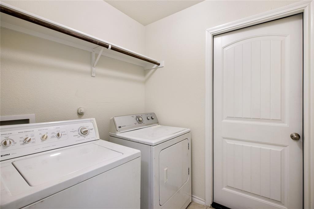 910 Amber Street Princeton, TX 75407 - Photo 20 of 24 a view of washer and dryer with bathroom in the background