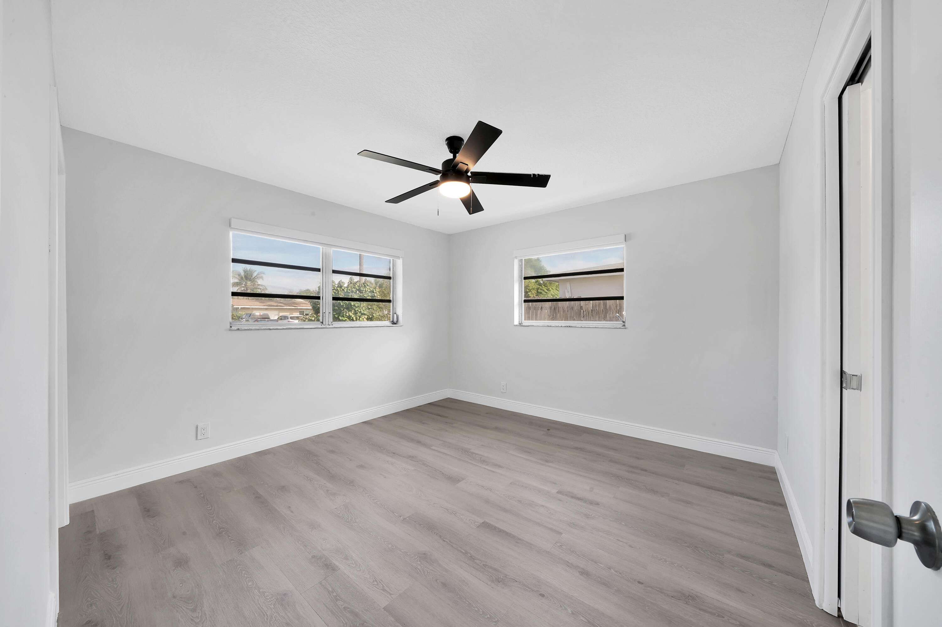 104 Palamino Circle Boca Raton, FL 33487 - Photo 11 of 34 an empty room with wooden floor ceiling fan and windows