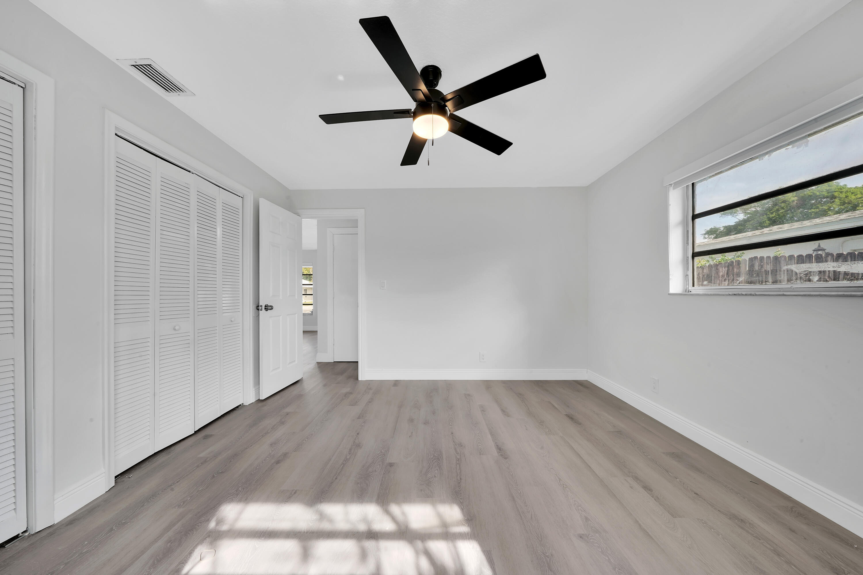 104 Palamino Circle Boca Raton, FL 33487 - Photo 19 of 34 a view of empty room with wooden floor and ceiling fan