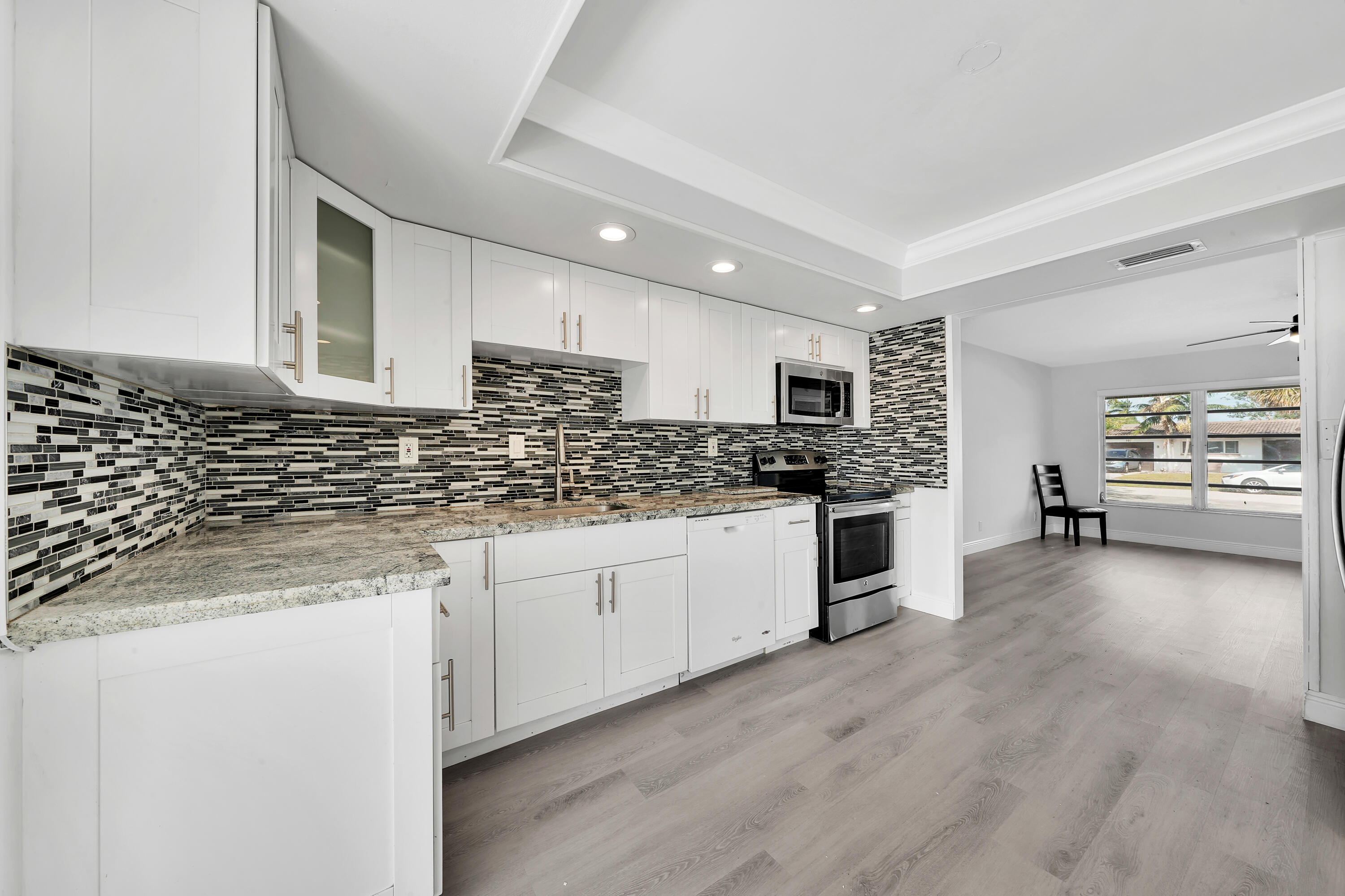 104 Palamino Circle Boca Raton, FL 33487 - Photo 3 of 34 a kitchen with granite countertop white cabinets and white appliances