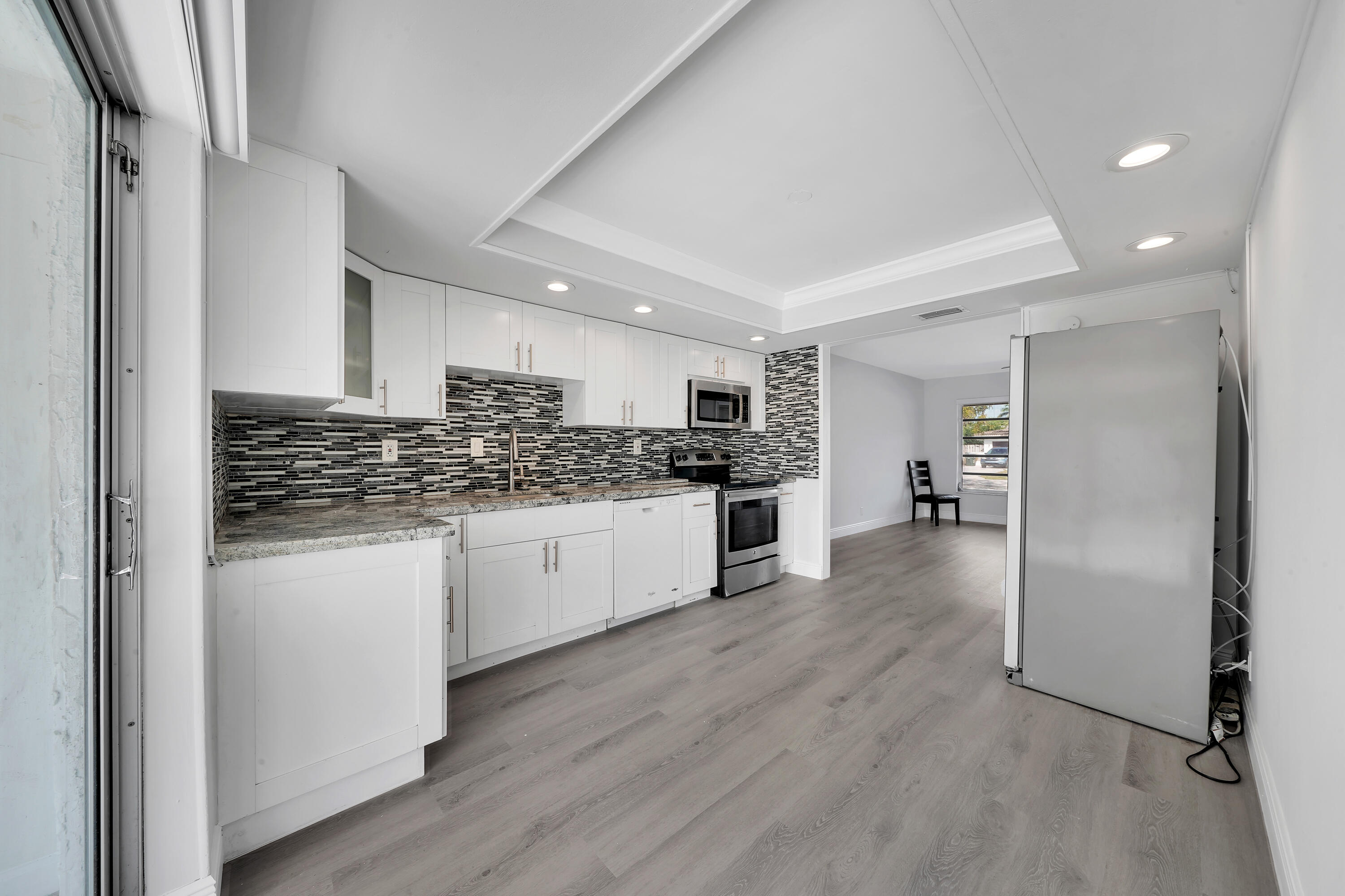 104 Palamino Circle Boca Raton, FL 33487 - Photo 4 of 34 a kitchen with a refrigerator and white cabinets