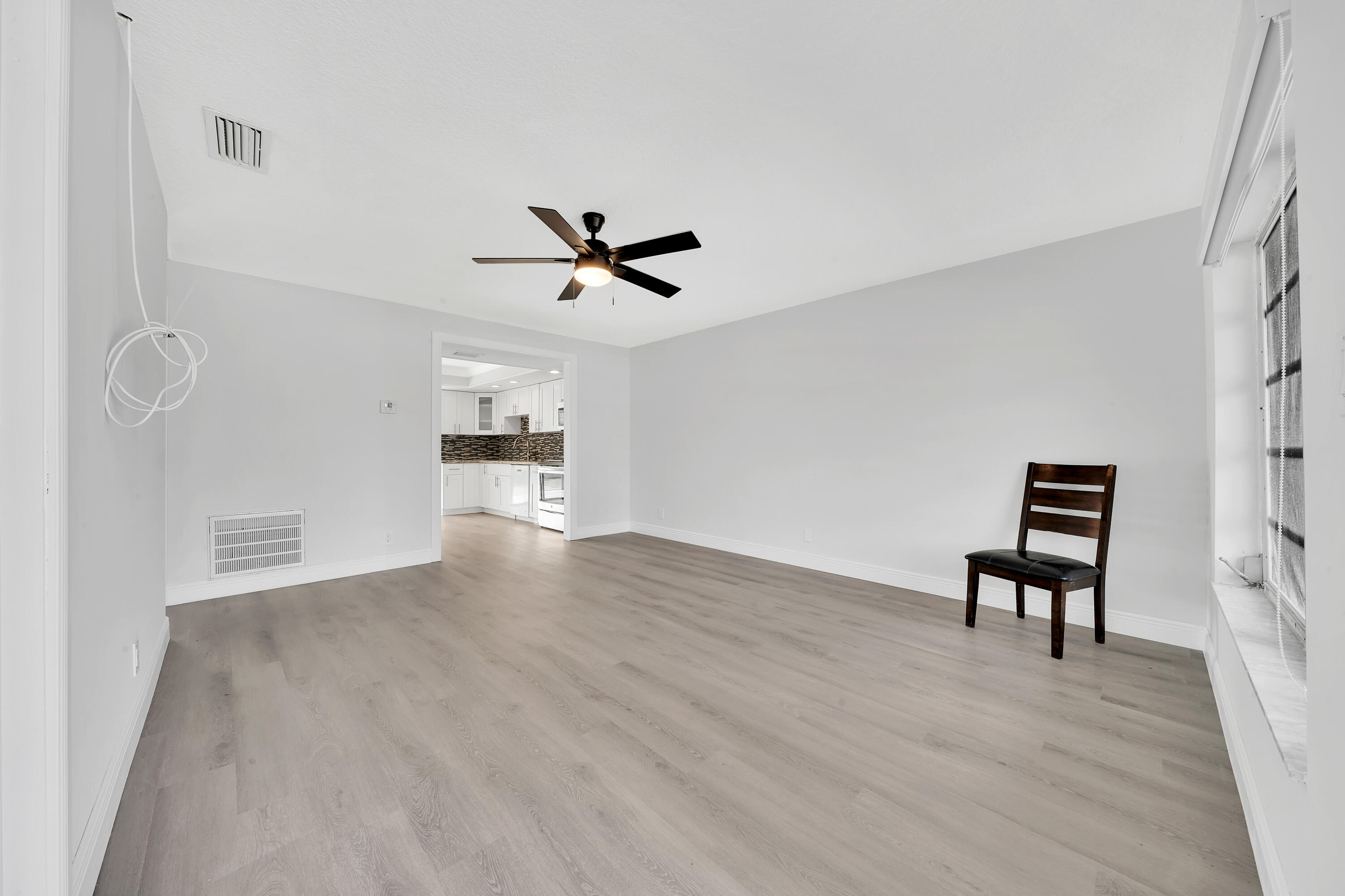 104 Palamino Circle Boca Raton, FL 33487 - Photo 7 of 34 a view of an empty room with a window and wooden floor