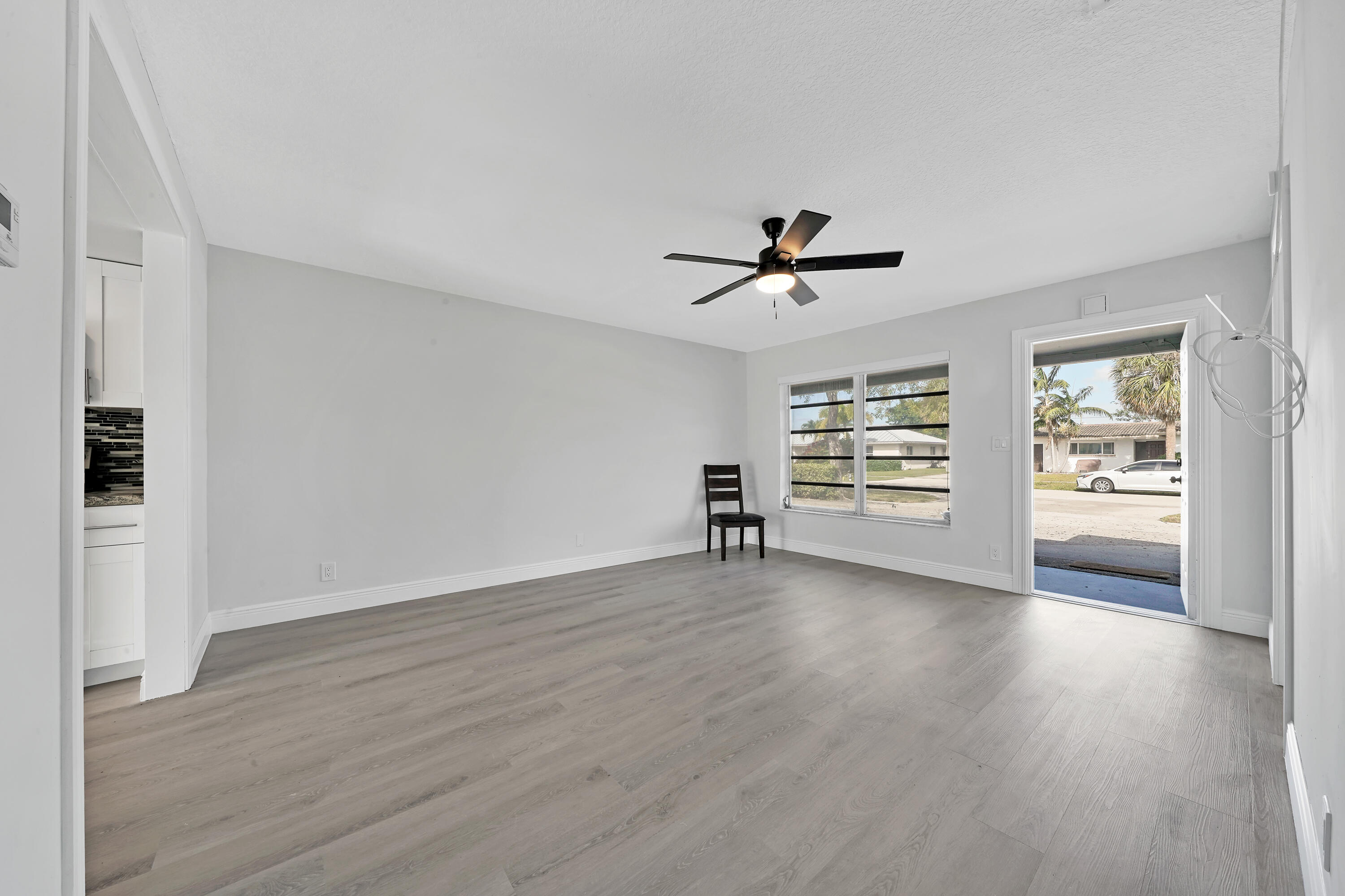 104 Palamino Circle Boca Raton, FL 33487 - Photo 8 of 34 a view of a livingroom with wooden floor and a ceiling fan