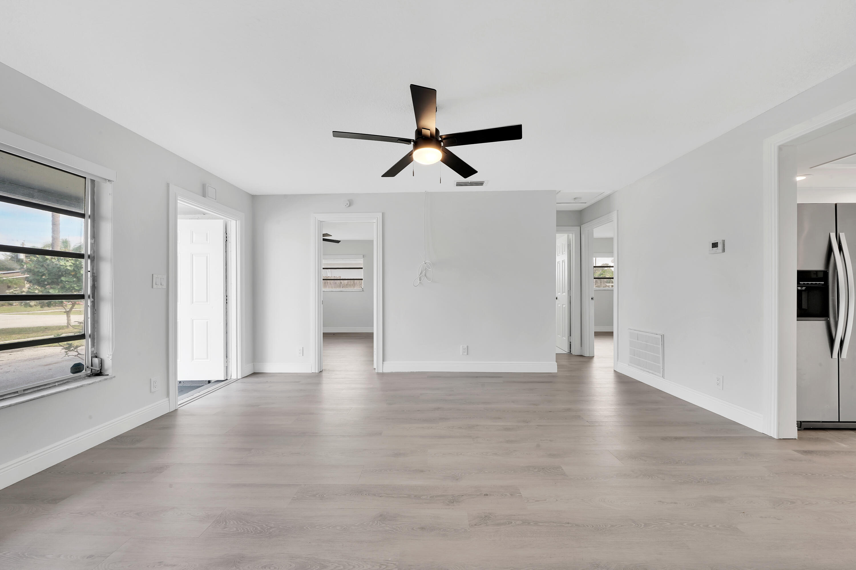 104 Palamino Circle Boca Raton, FL 33487 - Photo 9 of 34 a view of an empty room with window and wooden floor