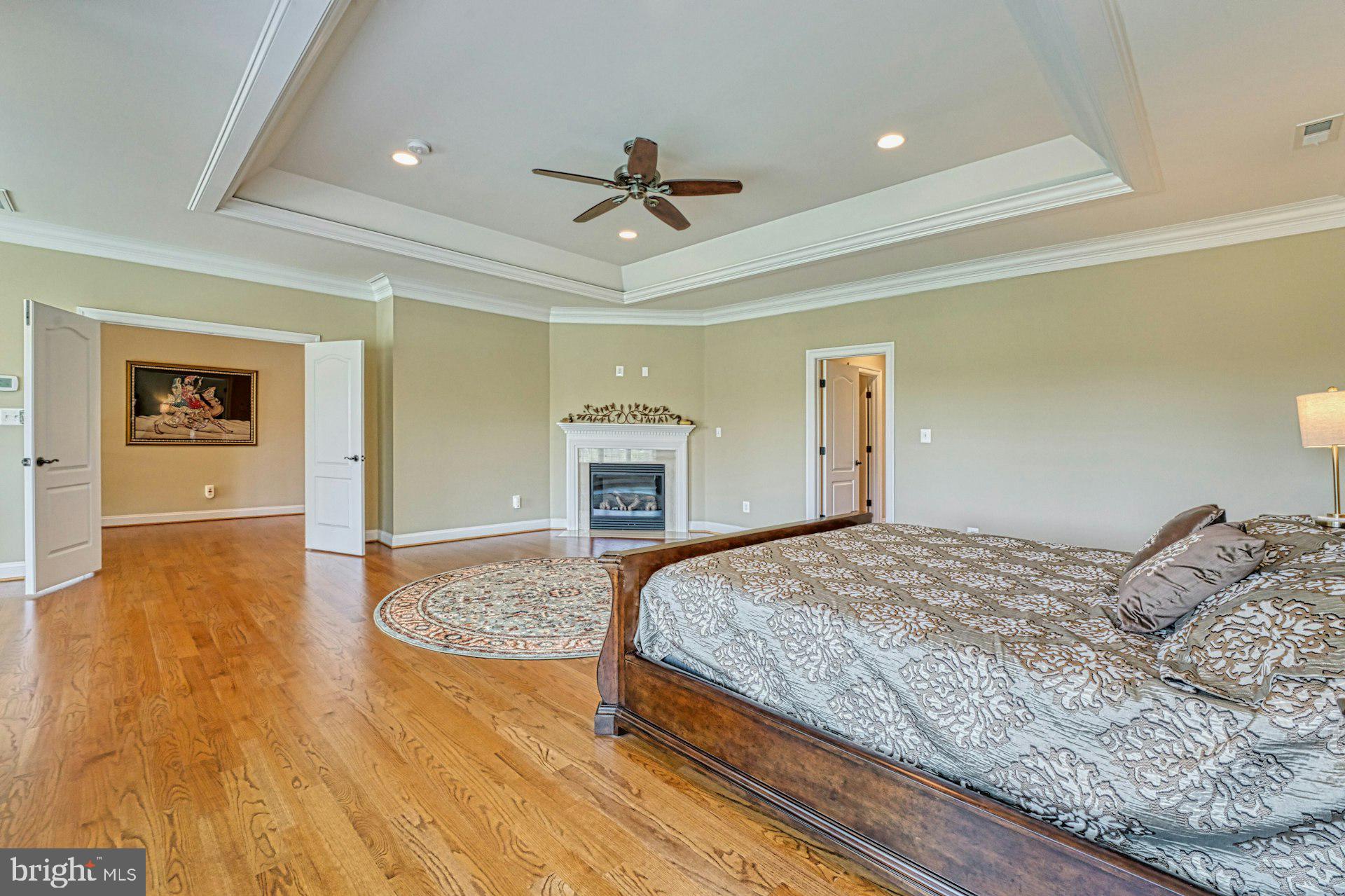 10405 Marbury Road Oakton, VA 22124 - Photo 33 of 72 a bedroom with a large bed a fireplace and wooden floor