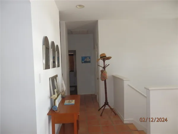 a living room with a black white checkered floor with a gaming machine and dining table