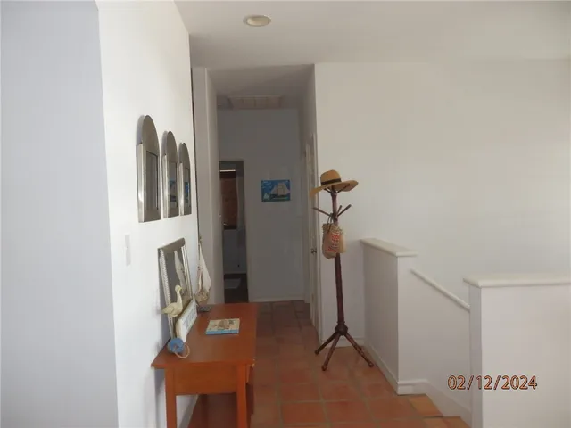 a living room with a black white checkered floor with a gaming machine and dining table
