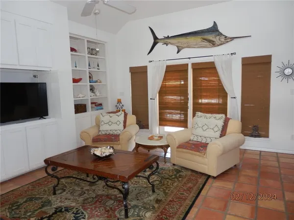 a living room with furniture a flat screen tv and a table