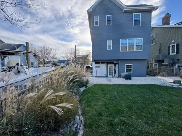 a view of house with yard and sitting area
