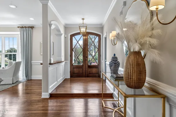 a living room with furniture a large window and wooden floor