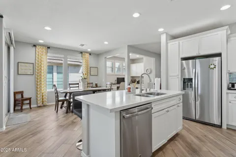 a kitchen with a refrigerator and white cabinets
